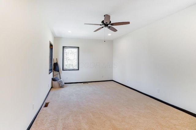 empty room featuring light colored carpet and ceiling fan