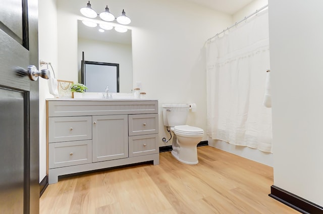 bathroom featuring vanity, wood-type flooring, and toilet