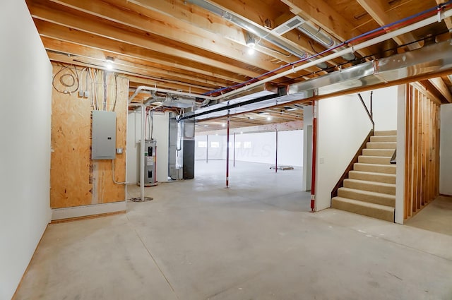 basement featuring electric panel, water heater, and heating unit