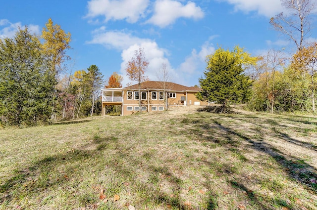 rear view of house featuring a yard and a sunroom