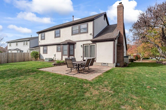 back of house featuring central AC, a patio area, and a yard