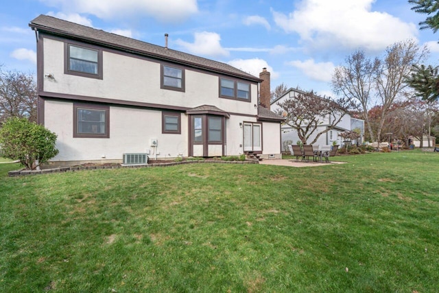 rear view of house with a patio area, central air condition unit, and a yard