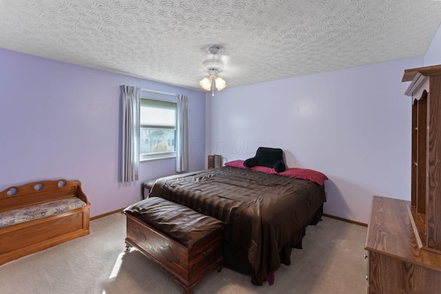 carpeted bedroom featuring ceiling fan and a textured ceiling