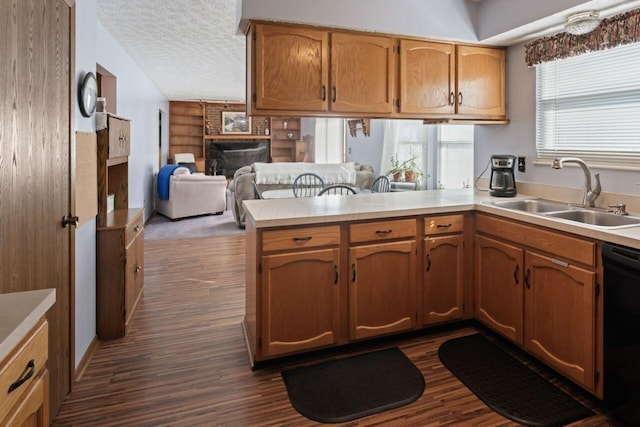 kitchen with kitchen peninsula, a textured ceiling, sink, dishwasher, and dark hardwood / wood-style floors