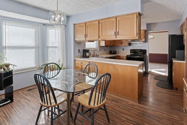 kitchen featuring black range with electric stovetop, dark hardwood / wood-style floors, kitchen peninsula, pendant lighting, and a textured ceiling