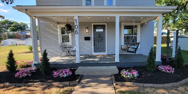 entrance to property with covered porch and a yard