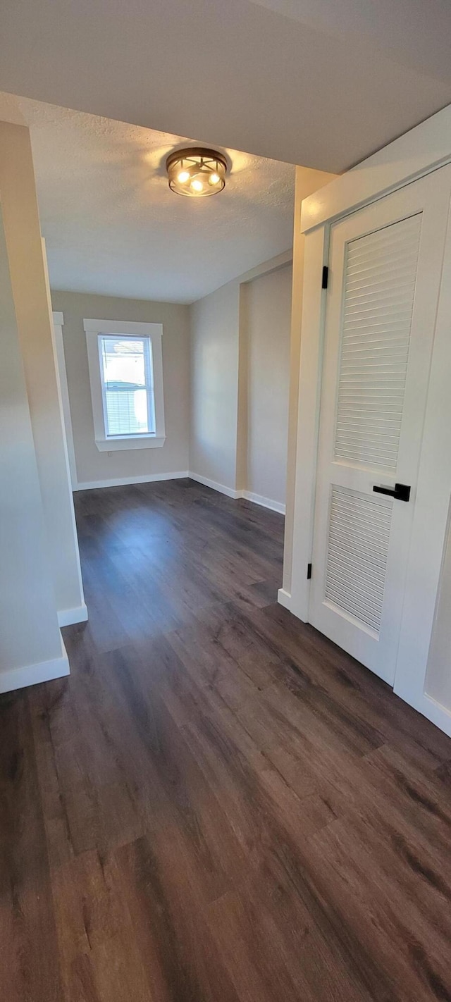 unfurnished room with a textured ceiling and dark hardwood / wood-style floors