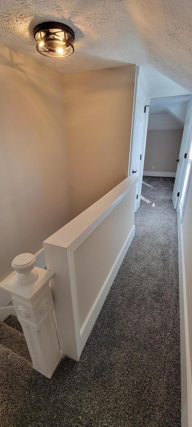 corridor featuring carpet and a textured ceiling