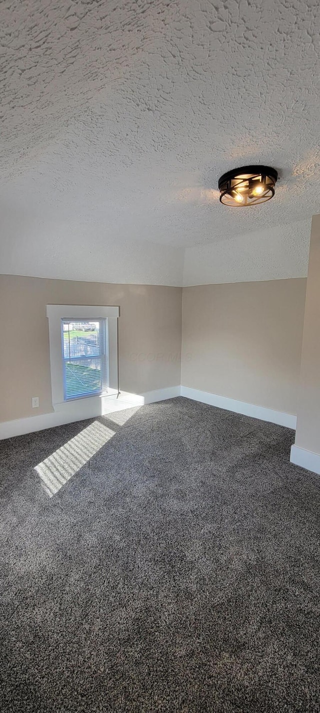 carpeted spare room featuring a textured ceiling