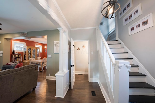 stairway featuring hardwood / wood-style flooring, decorative columns, ornamental molding, and a notable chandelier