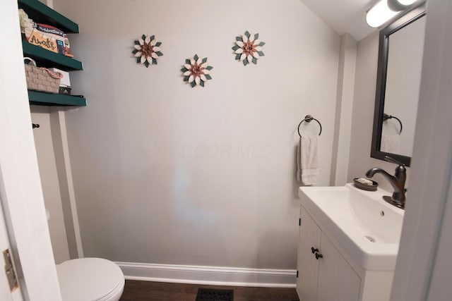 bathroom featuring hardwood / wood-style flooring, vanity, and toilet