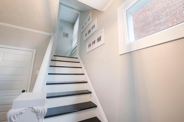 stairway featuring ornamental molding