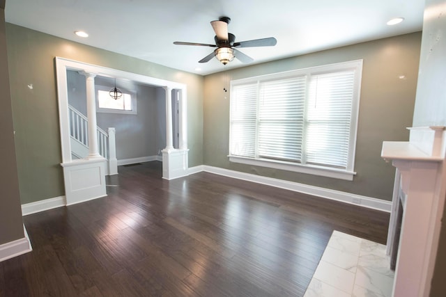 unfurnished living room with ceiling fan, a healthy amount of sunlight, and ornate columns