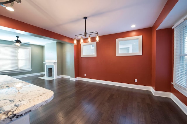 unfurnished dining area featuring dark hardwood / wood-style floors and ceiling fan