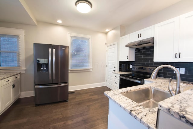 kitchen with appliances with stainless steel finishes, dark hardwood / wood-style floors, white cabinetry, and light stone counters