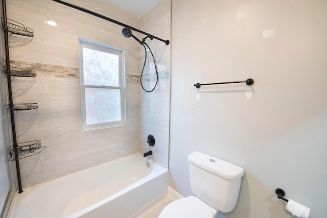 bathroom featuring toilet and tiled shower / bath