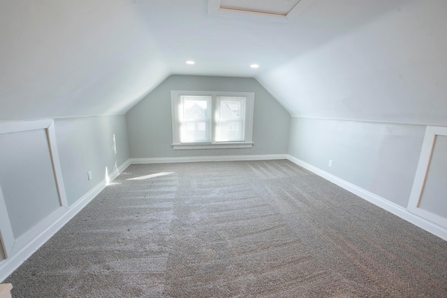 additional living space with carpet flooring and lofted ceiling