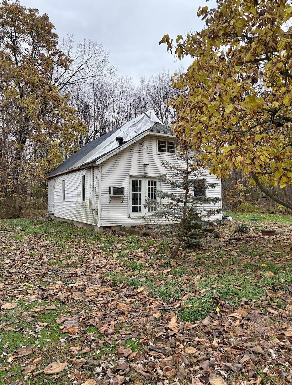 view of property exterior featuring french doors and a wall mounted air conditioner