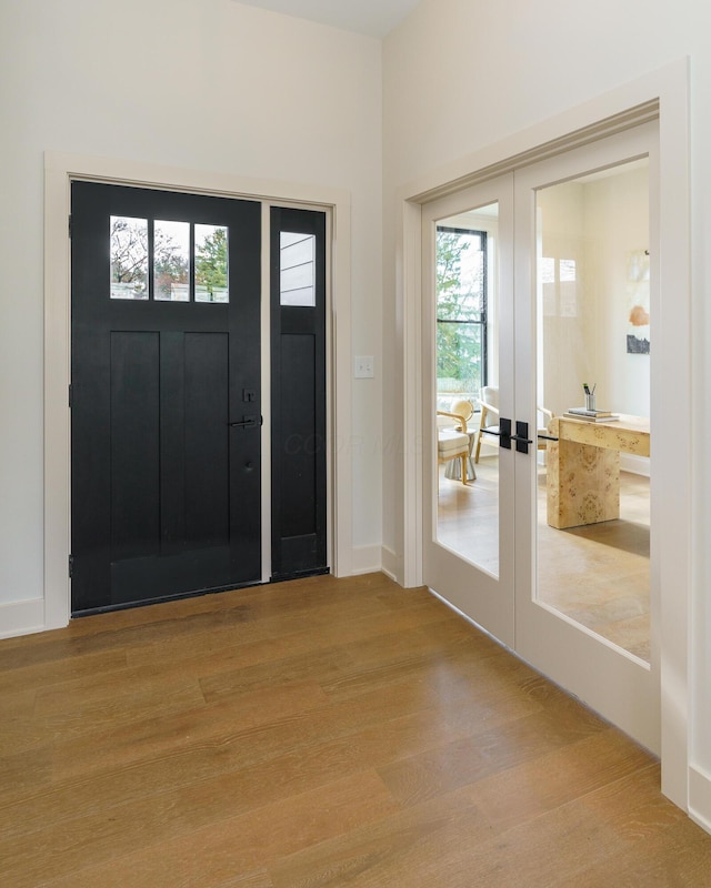 foyer entrance with light wood-type flooring and french doors