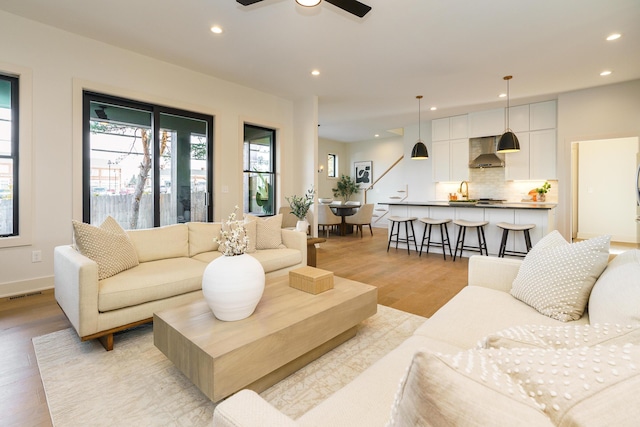 living room featuring ceiling fan and light wood-type flooring