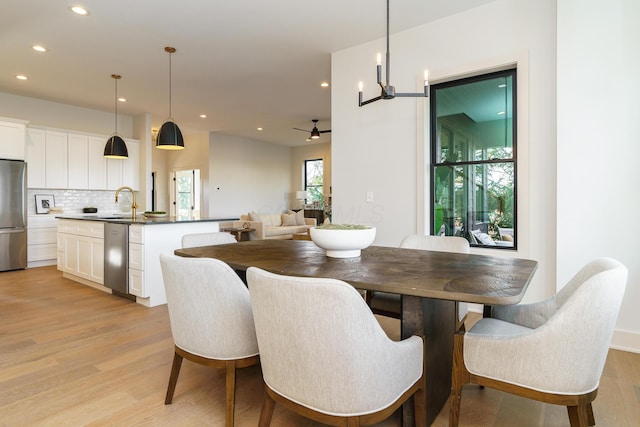 dining room with ceiling fan and light hardwood / wood-style floors