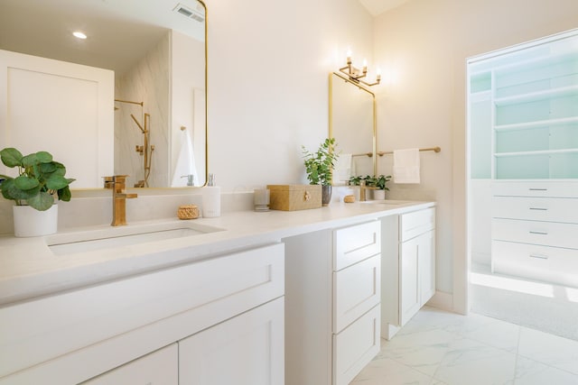 bathroom featuring tiled shower and vanity