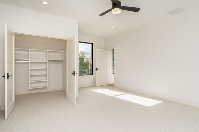 unfurnished bedroom with ceiling fan, light carpet, and a closet