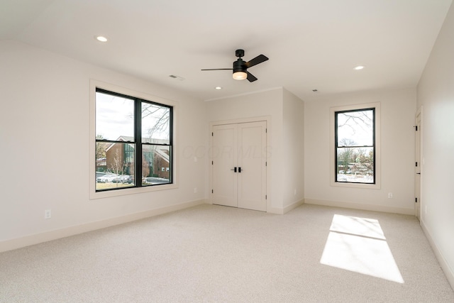 empty room with ceiling fan and light colored carpet