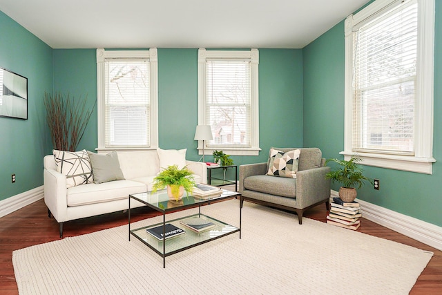 living room featuring dark wood-style floors, a wealth of natural light, and baseboards