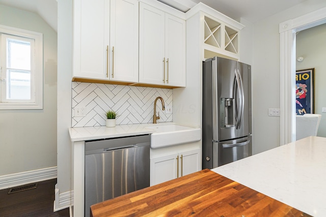 kitchen with appliances with stainless steel finishes, a sink, and white cabinets