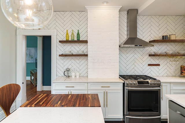 kitchen featuring open shelves, wall chimney range hood, stainless steel appliances, and light countertops