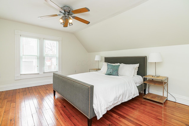 bedroom featuring lofted ceiling, dark wood-type flooring, a ceiling fan, and baseboards