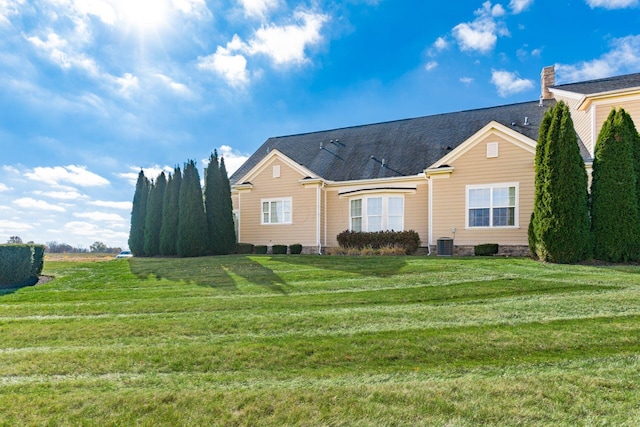 view of front facade with central AC and a front lawn