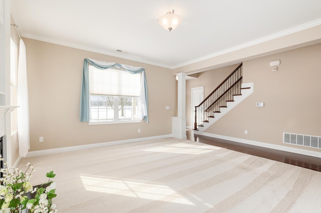 unfurnished living room featuring ornate columns and crown molding