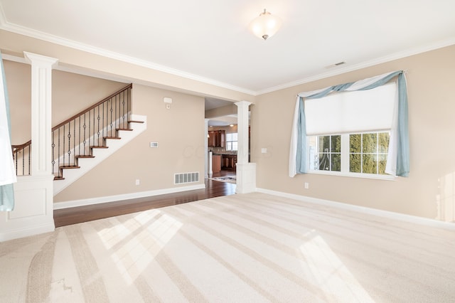 unfurnished living room with decorative columns, crown molding, and carpet