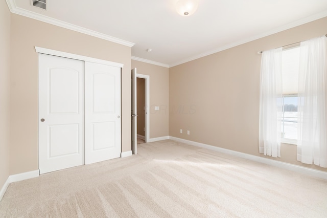 unfurnished bedroom featuring light carpet, ornamental molding, and a closet