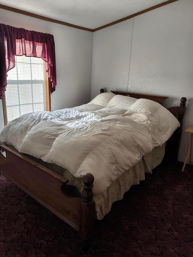 bedroom with crown molding, dark carpet, and a textured ceiling