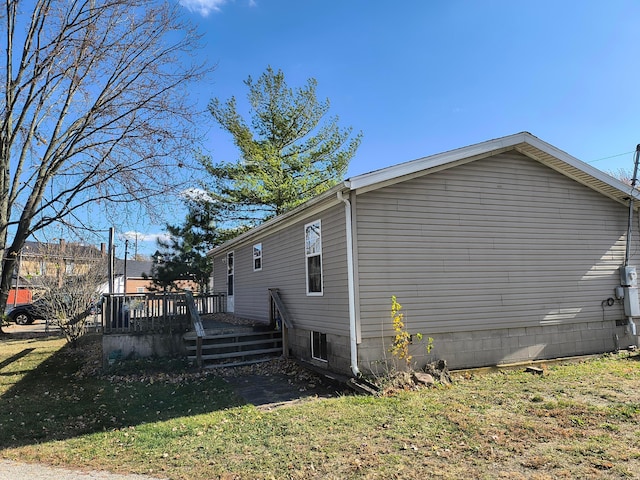 view of side of home with a yard and a deck