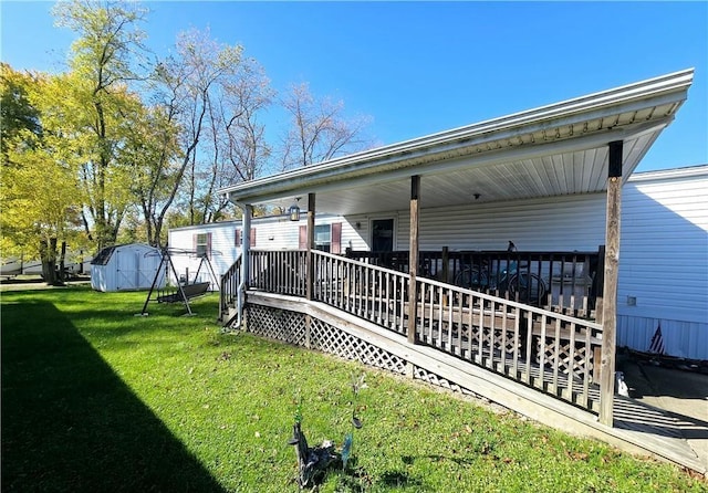 back of property with covered porch, a shed, and a yard