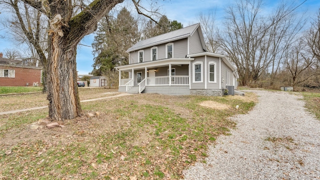 farmhouse with covered porch, a front lawn, and central air condition unit