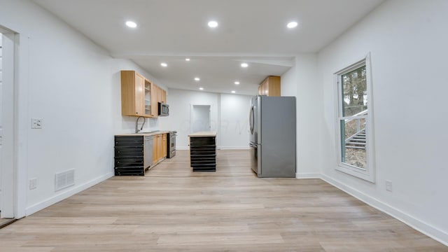 kitchen featuring light brown cabinetry, sink, light hardwood / wood-style flooring, and stainless steel appliances