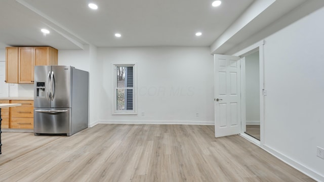 kitchen featuring stainless steel refrigerator with ice dispenser, light brown cabinetry, and light hardwood / wood-style flooring