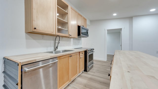 kitchen with sink, light brown cabinets, wooden counters, and appliances with stainless steel finishes