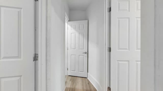 corridor with light hardwood / wood-style floors