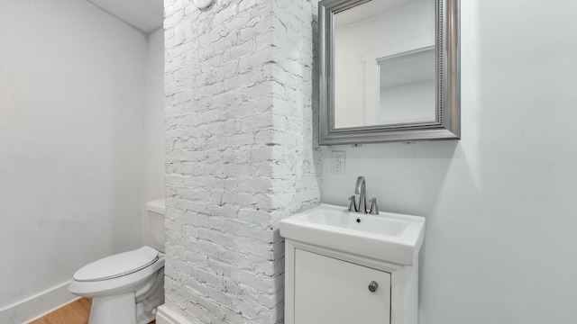 bathroom with vanity, toilet, and hardwood / wood-style floors