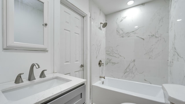 full bathroom featuring vanity, tiled shower / bath combo, and toilet