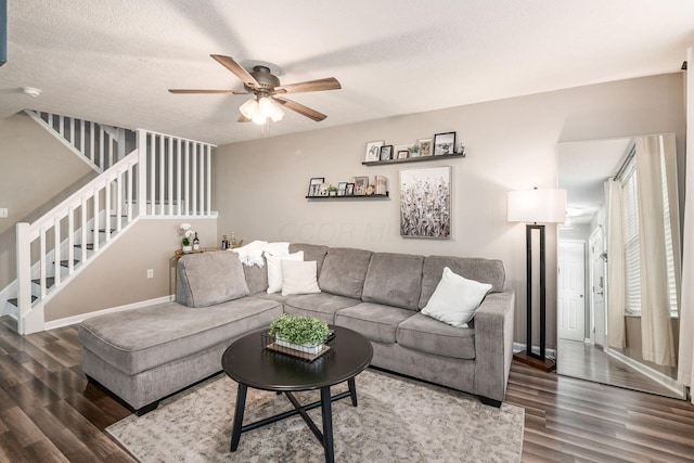 living room featuring a textured ceiling, dark hardwood / wood-style floors, and ceiling fan