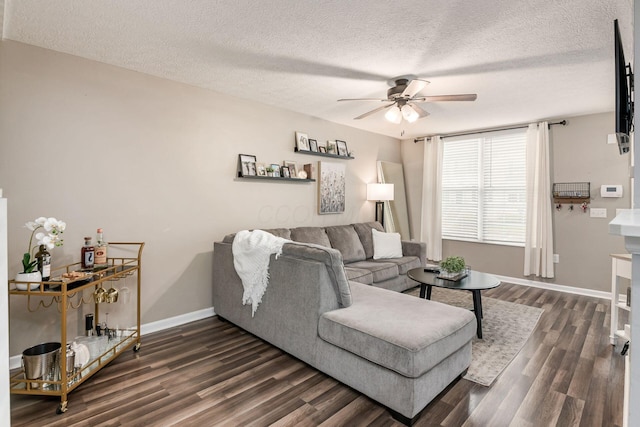 living room with ceiling fan, dark wood-type flooring, and a textured ceiling