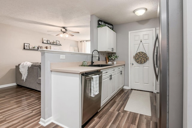 kitchen featuring white cabinets, appliances with stainless steel finishes, dark wood-type flooring, and sink