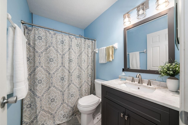 bathroom featuring vanity, a textured ceiling, and toilet